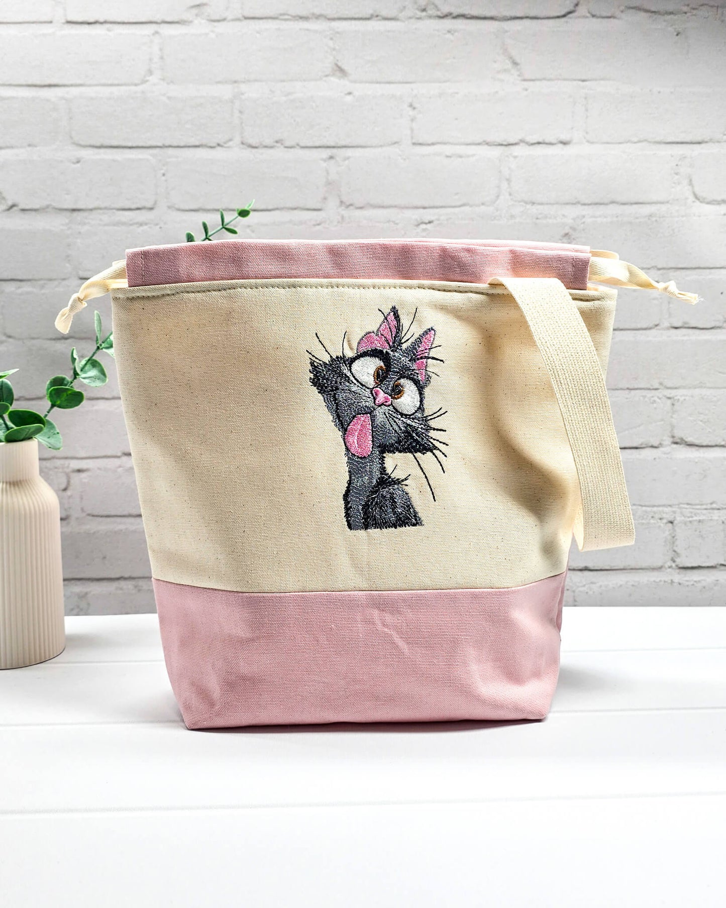 Projekttasche Tuva M aus hellem Canvas und Rosa mit gestickter frecher Katze und Kordelzugverschluss. Handgenäht in Bayern von Nadelmikado.