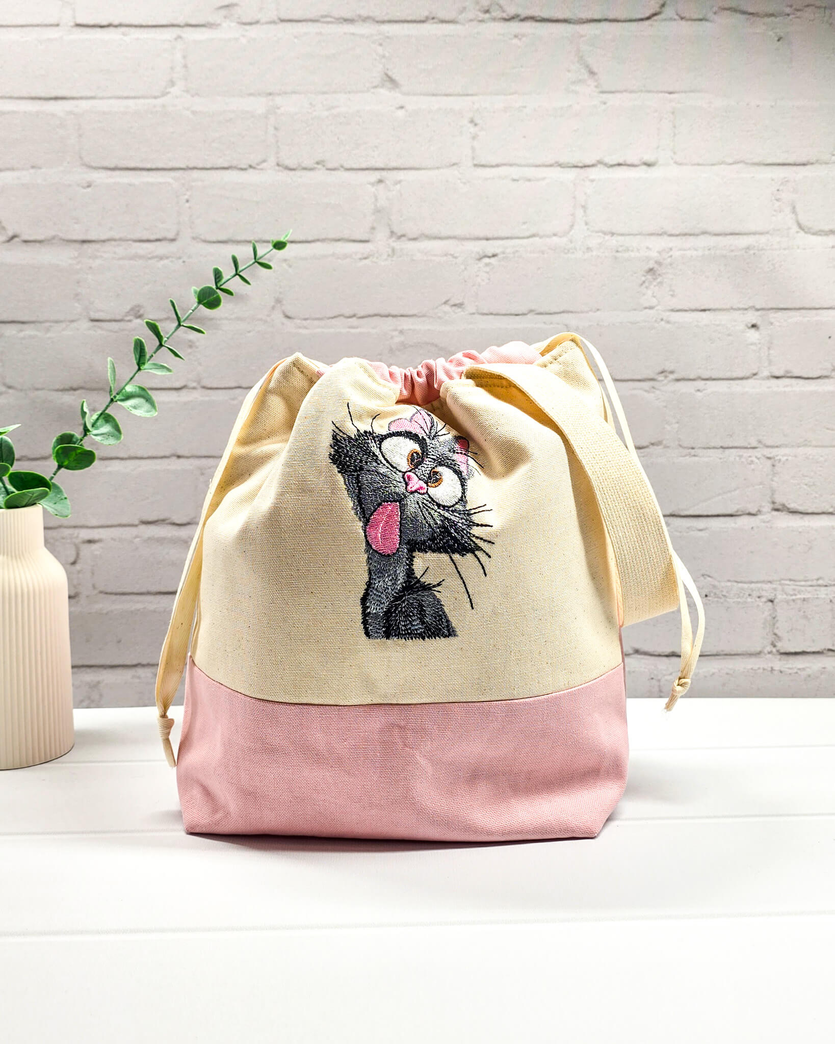 Projekttasche Tuva M aus hellem Canvas und Rosa mit gestickter frecher Katze und Kordelzugverschluss. Handgenäht in Bayern von Nadelmikado.