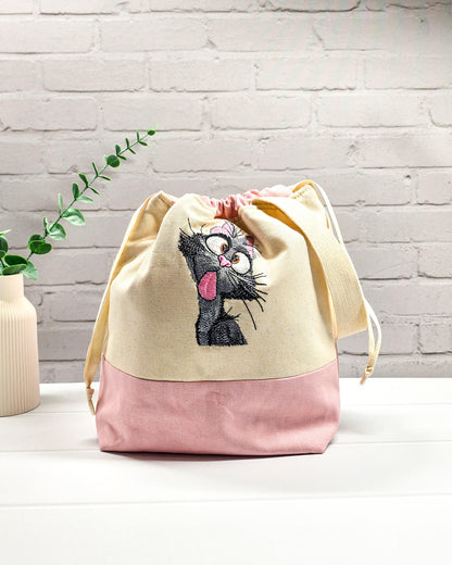 Projekttasche Tuva M aus hellem Canvas und Rosa mit gestickter frecher Katze und Kordelzugverschluss. Handgenäht in Bayern von Nadelmikado.