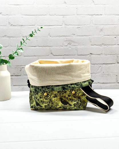 Mittlere grüne Projekttasche mit Trageriemen, gemustert mit Raben und Rosen, genutzt als Strickbeutel für ein Tuchprojekt mit bis zu 400g Wolle. Handgenäht in Bayern von Nadelmikado.