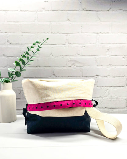 Projekttasche Tuva M aus hellem Canvas und schwarzem Stoff mit drei gestickten, tanzenden Schafen, pink-schwarz gepunktetem Kordelzug-Bündchen und cremefarbenem Tragegurt. Bietet Platz für 400g Wolle und schützt das Strickzeug vor Verheddern. Handgenäht in Bayern von Nadelmikado.