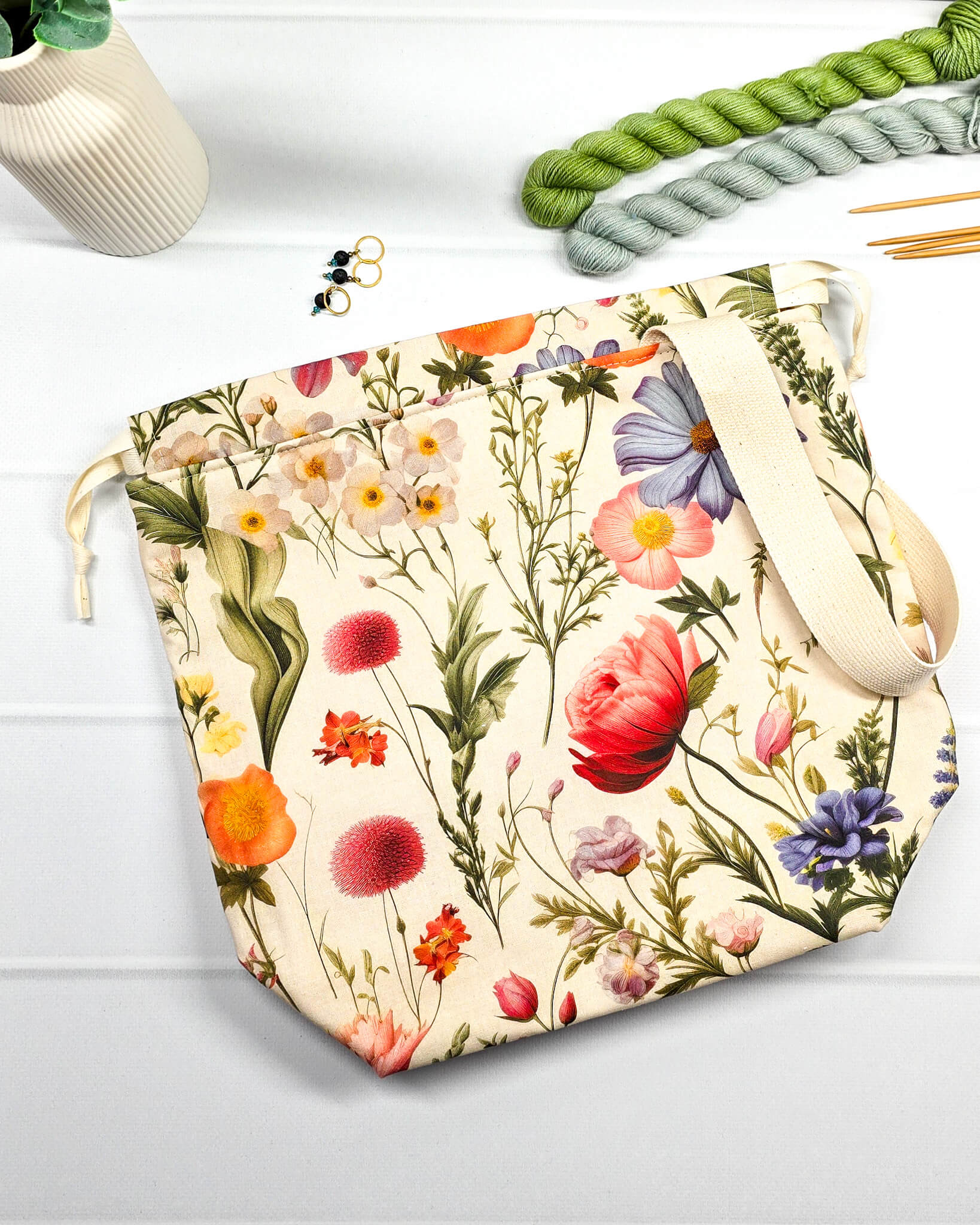 Projektbeutel mit buntem Blumenmuster für die sichere Aufbewahrung deines Tuch-Projekts unterwegs. Handgenäht in Bayern von Nadelmikado.