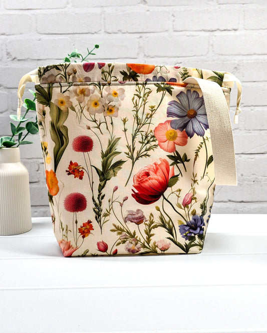 Projektbeutel mit buntem Blumenmuster für die sichere Aufbewahrung deines Tuch-Projekts unterwegs. Handgenäht in Bayern von Nadelmikado.