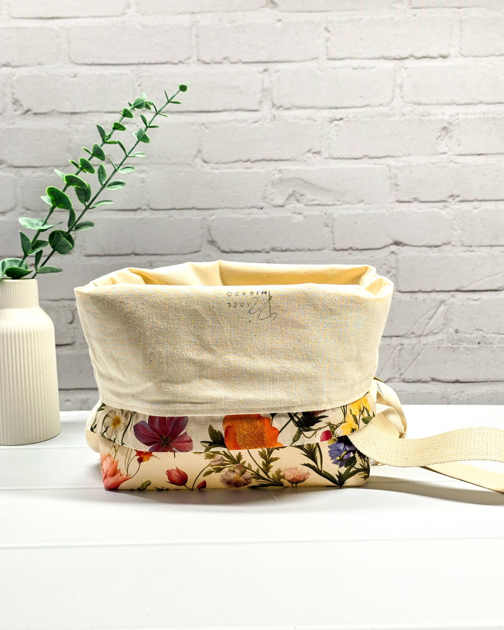 Projektbeutel mit buntem Blumenmuster für die sichere Aufbewahrung deines Tuch-Projekts unterwegs. Handgenäht in Bayern von Nadelmikado.