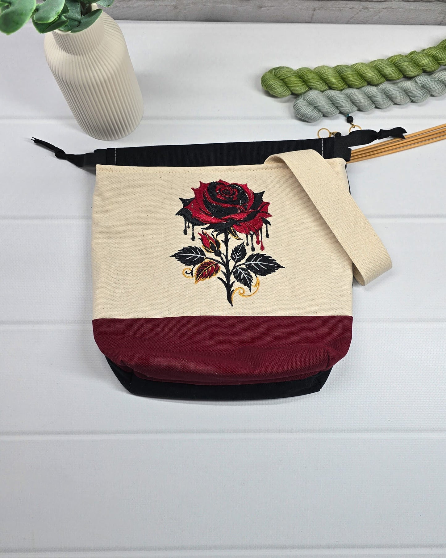 Projekttasche Tuva S aus hellem Canvas und Bordeaux mit gestickter Gothic Rose und schwarzem Kordelzugkragen. Handgenäht in Bayern von Nadelmikado.