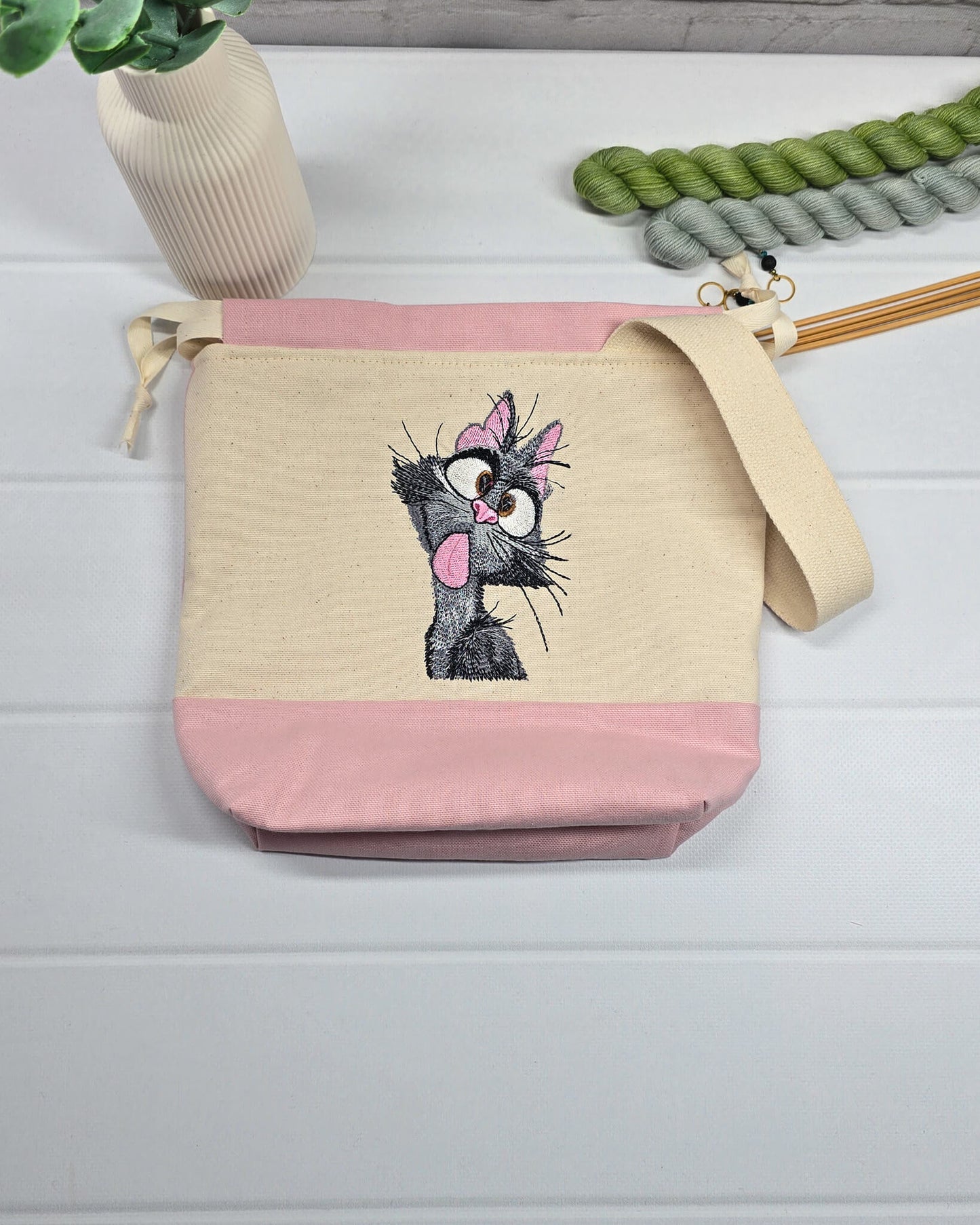 Projekttasche Tuva S aus hellem Canvas und Rosa mit gestickter frecher Katze und Kordelzugkragen. Handgenäht in Bayern von Nadelmikado.