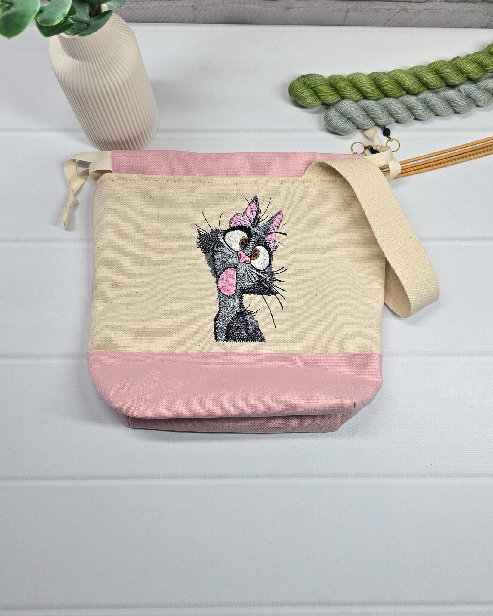 Projekttasche Tuva S aus hellem Canvas und Rosa mit gestickter frecher Katze und Kordelzugkragen. Handgenäht in Bayern von Nadelmikado.
