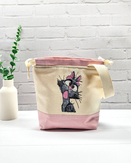 Projekttasche Tuva S aus hellem Canvas und Rosa mit gestickter frecher Katze und Kordelzugkragen. Handgenäht in Bayern von Nadelmikado.