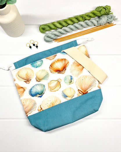 Projektbeutel mit Muschelmuster, blauem Canvas-Boden, weißem Kordelzug und Tragegurt. Platz für 200g Wolle. Handgenäht in Bayern von Nadelmikado.