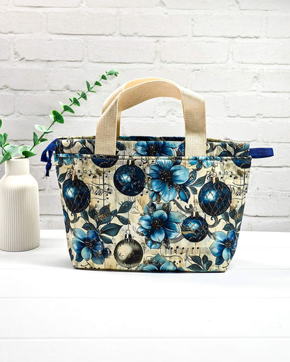 Stricktasche mit Henkeln, blauen Blüten, Weihnachtskugeln und Notenmotiven. Handgenäht in Bayern von NadelMikado.