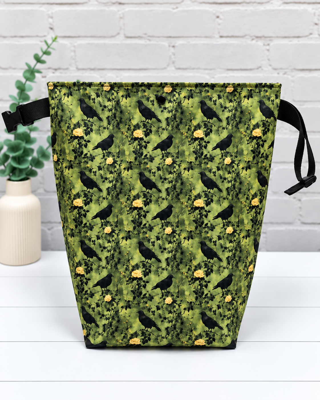 Rolltop-Projekttasche Rika mit schwarzen Raben, gelben Rosen und grünen Blättern auf olivgrünem Hintergrund. Handgenäht in Bayern von Nadelmikado.