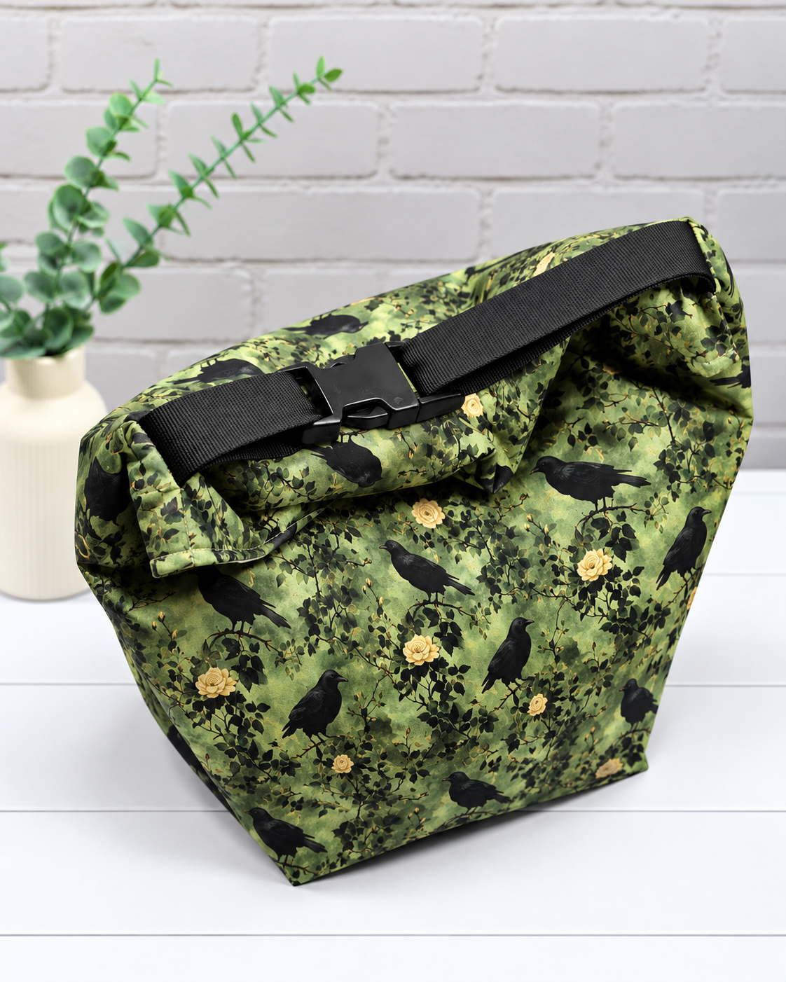 Rolltop-Projekttasche Rika mit schwarzen Raben, gelben Rosen und grünen Blättern auf olivgrünem Hintergrund. Handgenäht in Bayern von Nadelmikado.