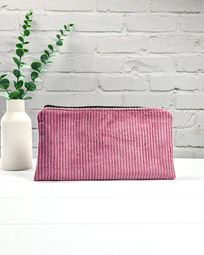 Kleine Reißverschlusstasche aus altrosafarbenem Cord-Stoff für Strickzubehör, flach liegend auf weißem Untergrund mit Schere, Garn und Nadeln. Handgenäht in Bayern von Nadelmikado.
