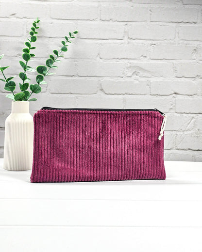 Kleine Reißverschlusstasche aus beerenfarbenem Cord-Stoff auf hellem Untergrund mit Strickzubehör. Handgenäht in Bayern von Nadelmikado. 