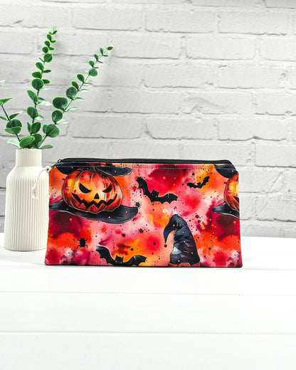 Längliche Reißverschlusstasche aus Stoff mit gruseligen Halloween-Kürbissen, Hexenhüten und Fledermäusen für Handarbeitszubehör. Handgenäht in Bayern von Nadelmikado. 