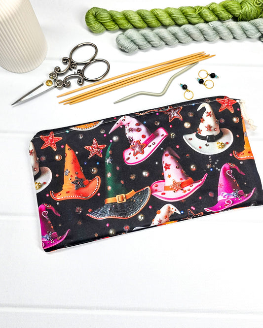 Kleine Reißverschlusstasche aus schwarzem Stoff mit bunten Hexenhüten als Zubehör-Etui für Handarbeiten. Genäht in Bayern von Nadelmikado.