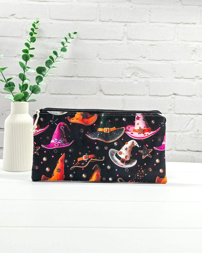 Kleine Reißverschlusstasche aus schwarzem Stoff mit bunten Hexenhüten als Zubehör-Etui für Handarbeiten. Genäht in Bayern von Nadelmikado.
