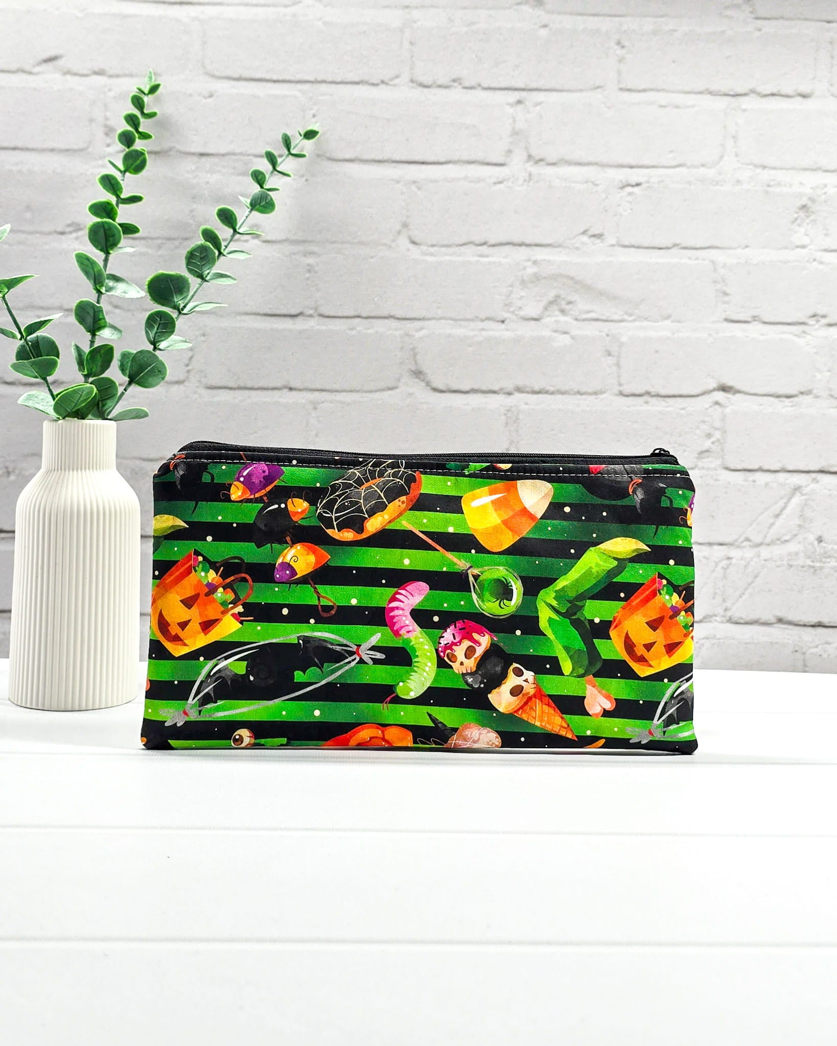 Längliche Tasche mit grün-schwarzen Streifen und bunten Halloween-Süßigkeiten. Handgenäht in Bayern von Nadelmikado.