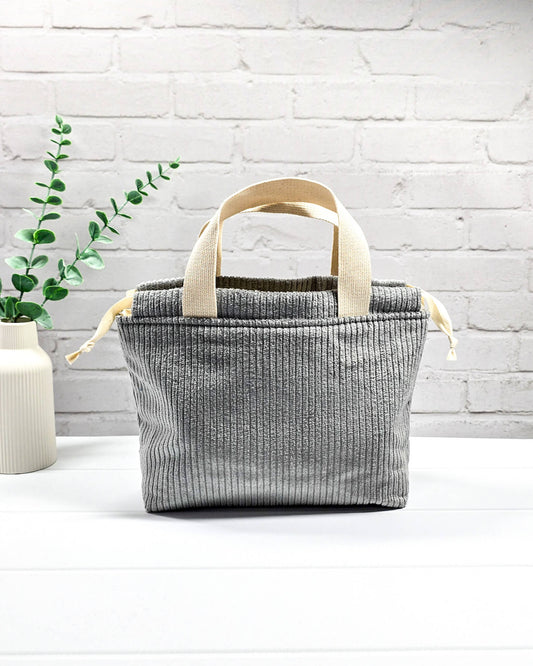 Kleine Stricktasche aus grauem Cordstoff mit zwei hellen Gurtband-Tragegriffen. Handgenäht in Bayern von Nadelmikado