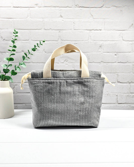 Kleine Stricktasche aus grauem Cordstoff mit zwei hellen Gurtband-Tragegriffen. Handgenäht in Bayern von Nadelmikado