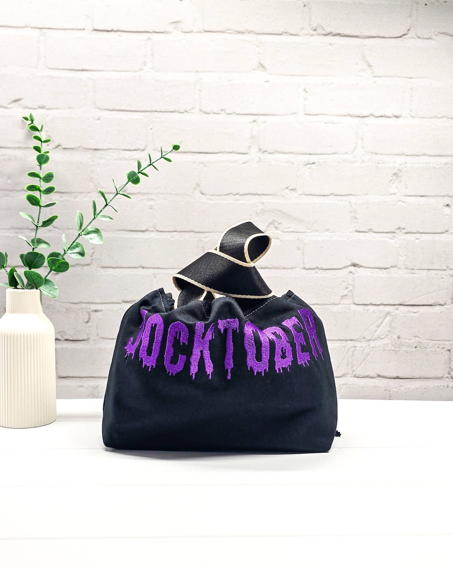 Schwarze Stricktasche Alva S mit violettem Socktober-Schriftzug, handgenäht und bestickt in Bayern von NadelMikado