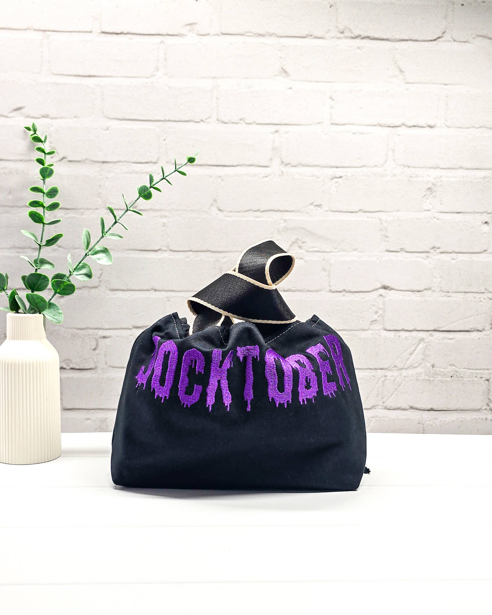 Schwarze Stricktasche Alva S mit violettem Socktober-Schriftzug, handgenäht und bestickt in Bayern von NadelMikado