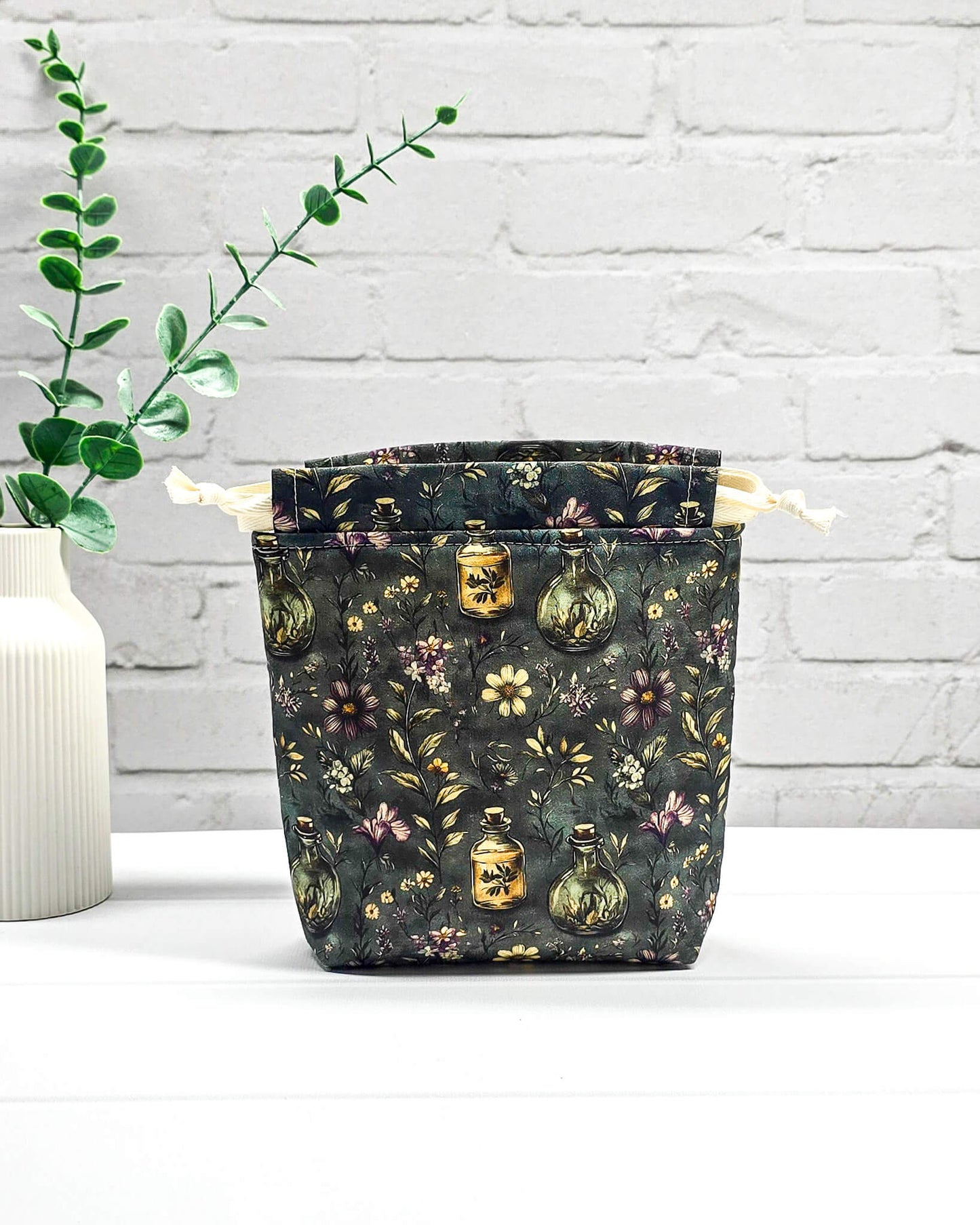 Kleine handgemachte Stricktasche für 50 g Wolle mit dunklem botanischem Muster, Blüten und Apothekerfläschchen. Handgenäht in Bayern von NadelMikado.