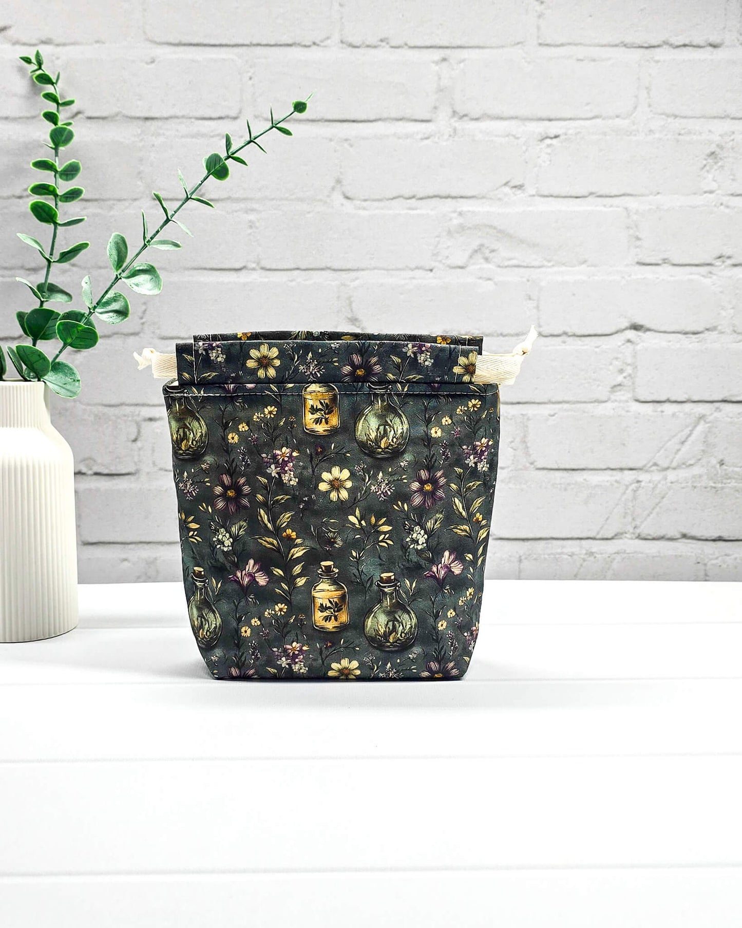 Kleine handgemachte Stricktasche für 50 g Wolle mit dunklem botanischem Muster, Blüten und Apothekerfläschchen. Handgenäht in Bayern von NadelMikado.