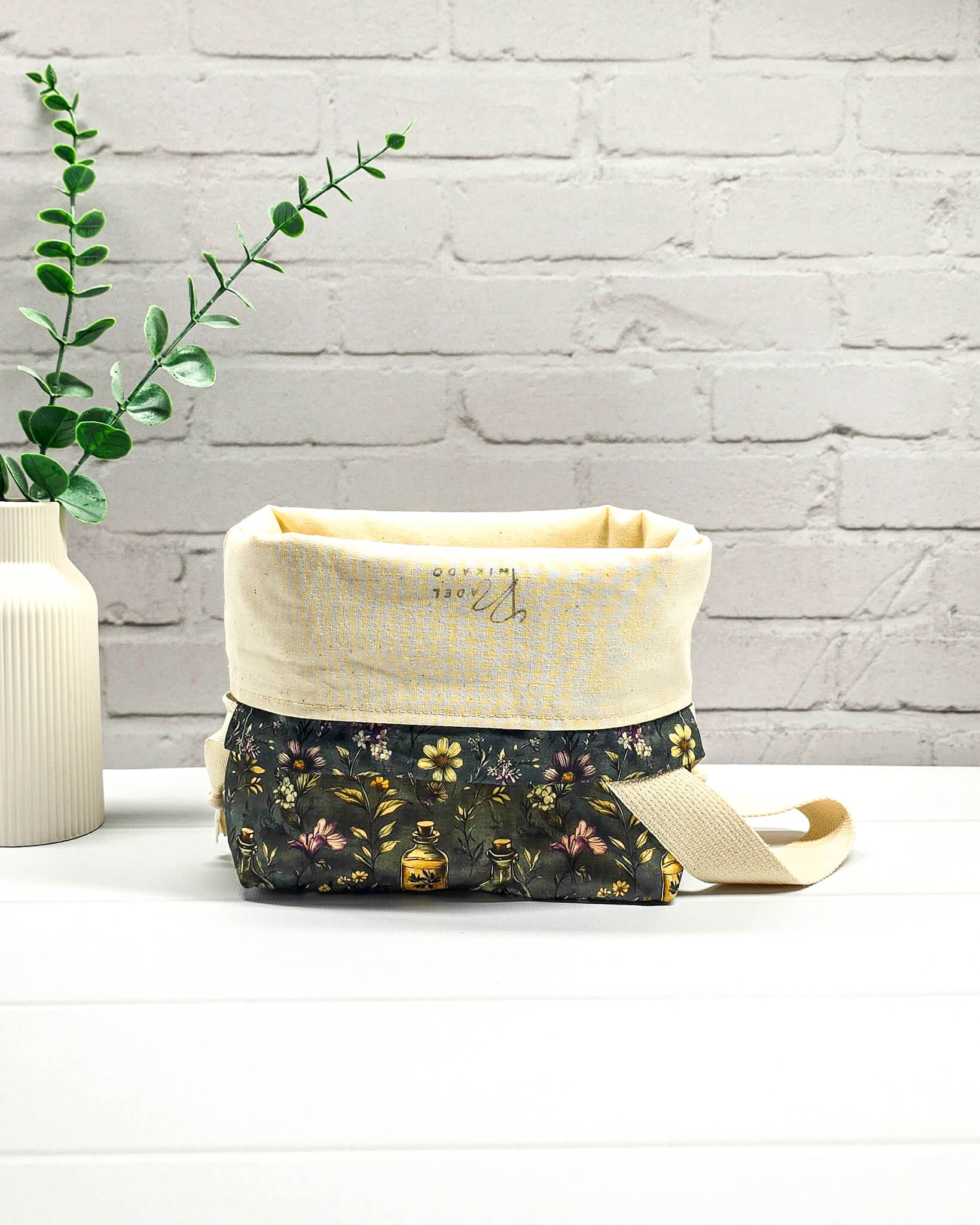 Stricktasche für bis zu 200 g Wolle im dunklen Botanical Apothecary Design mit Blüten und nostalgischen Apothekerfläschchen. Handgenäht in Bayern von NadelMikado.