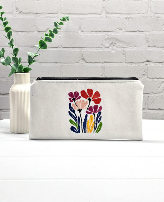 Flaches, weißes Canvas-Etui Runa mit bunter Wildblumen-Stickerei, entworfen zur sicheren und knickfreien Aufbewahrung von Stricknadeln, Nadelseilen und Scheren im Projektbeutel. Handgenäht in Bayern von Nadelmikado.