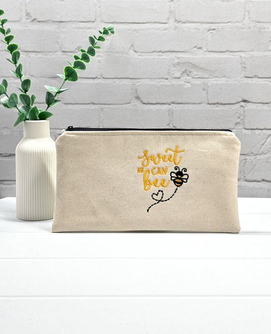 Flache, rechteckige Zip Pouch Runa aus beigem Canvas mit gestickter Biene und gelbem Schriftzug, handgenäht in Bayern von Nadelmikado