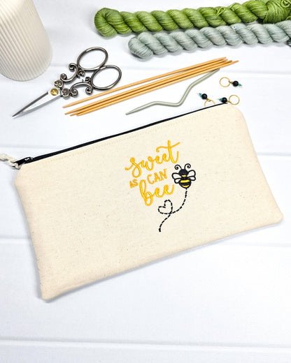 Flache, rechteckige Zip Pouch Runa aus beigem Canvas mit gestickter Biene und gelbem Schriftzug, handgenäht in Bayern von Nadelmikado