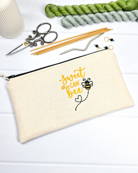 Flache, rechteckige Zip Pouch Runa aus beigem Canvas mit gestickter Biene und gelbem Schriftzug, handgenäht in Bayern von Nadelmikado