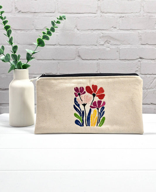 Flache, rechteckige Zip Pouch Runa aus beigem Canvas mit einer großen, bunt gestickten Blumengruppe, ideal zum platzsparenden Einsortieren von Stricknadeln und Seilen. Handgenäht in Bayern von Nadelmikado.