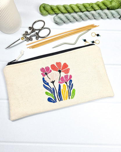 Flache, rechteckige Zip Pouch Runa aus beigem Canvas mit einer großen, bunt gestickten Blumengruppe, ideal zum Aufbewahren von Stricknadeln und Seilen. Handgenäht in Bayern von Nadelmikado.
