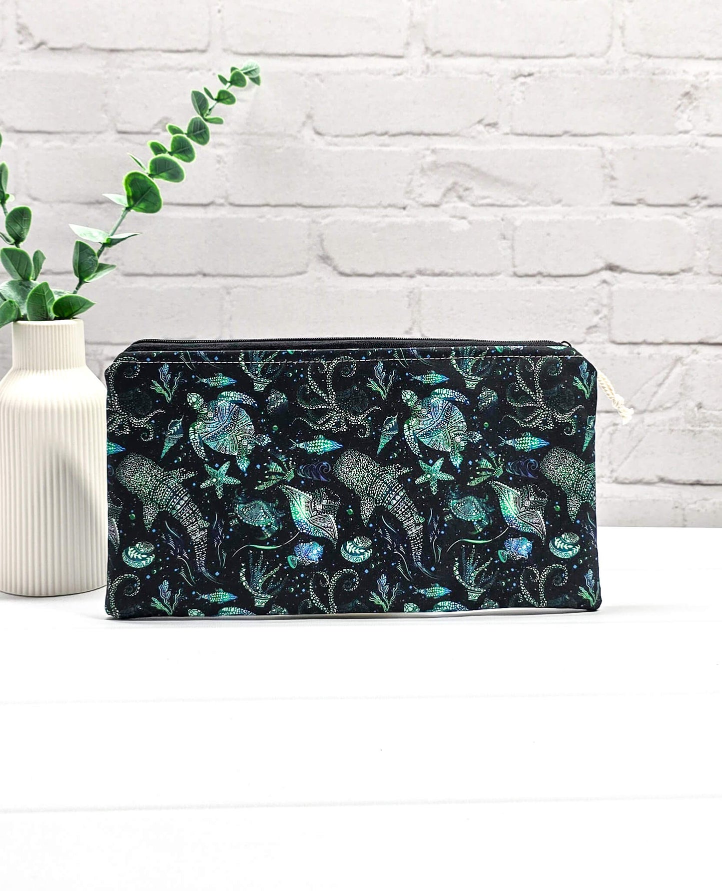 Flache, rechteckige Zip Pouch Runa aus schwarzem Stoff mit leuchtend grün-blauen Meerestieren, handgenäht in Bayern von Nadelmikado