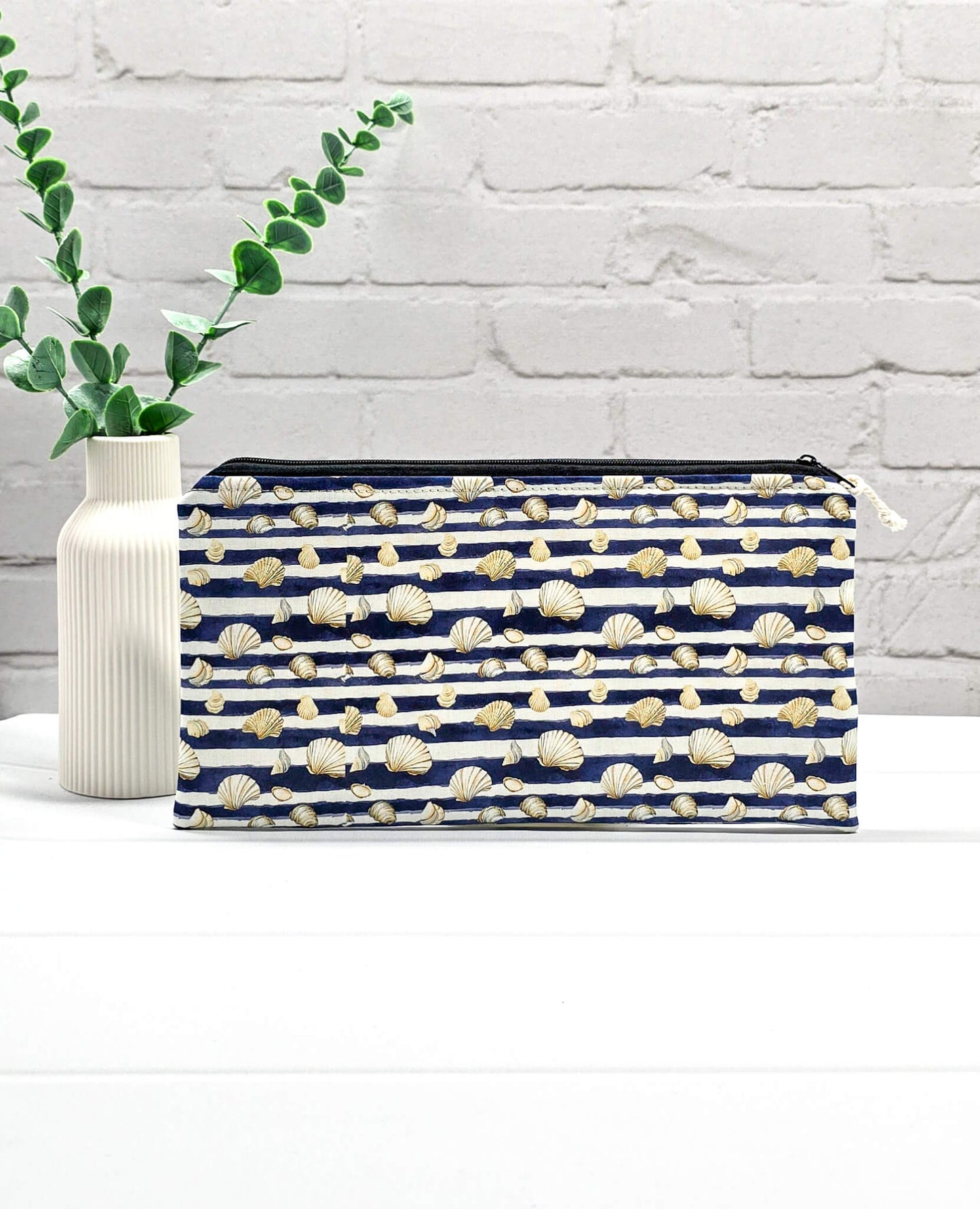 Flache, rechteckige Zip Pouch Runa mit dunkelblau-weißen Querstreifen und kleinen Muschelmotive, handgenäht in Bayern von Nadelmikado