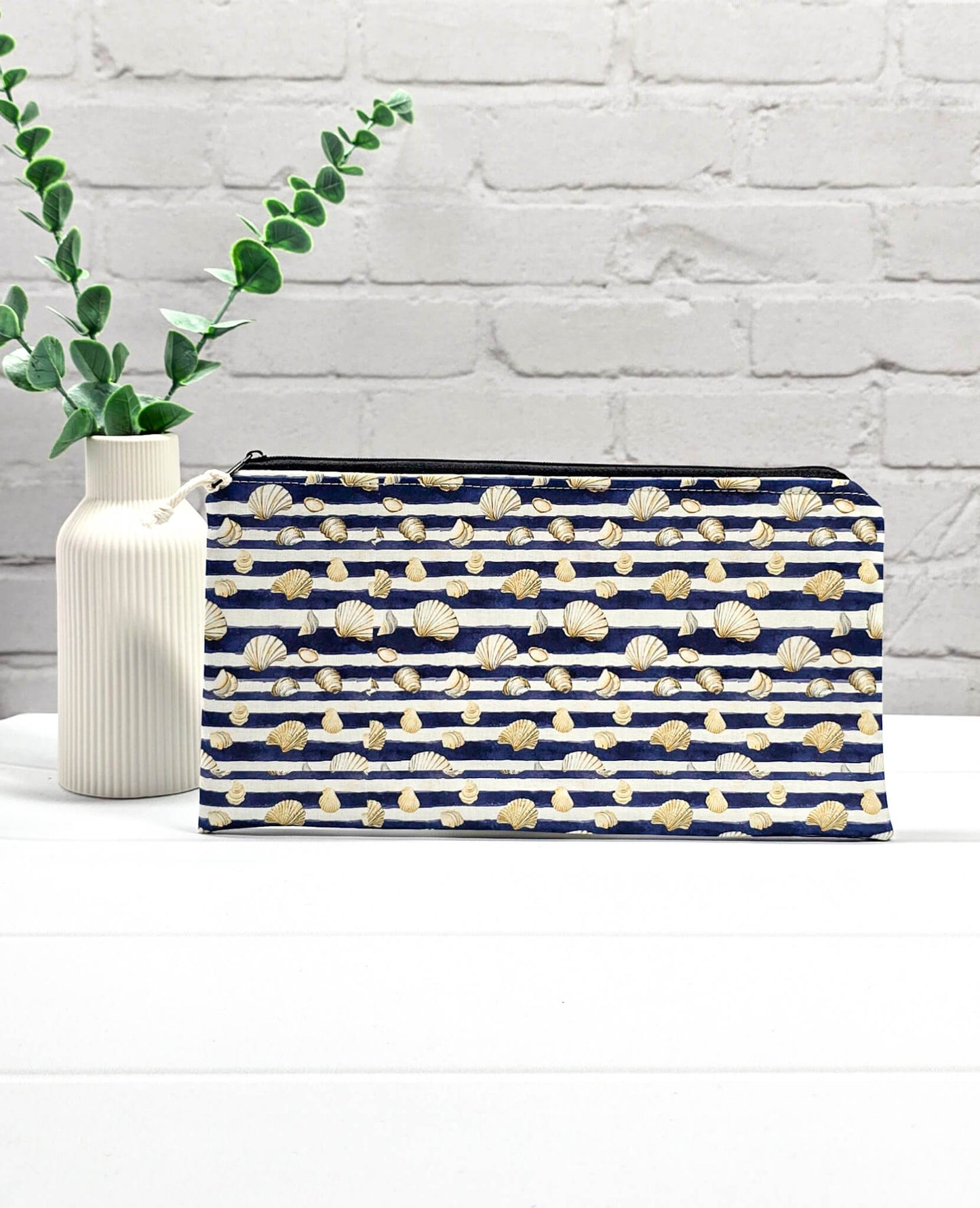 Flache, rechteckige Zip Pouch Runa mit dunkelblau-weißen Querstreifen und kleinen Muschelmotive, handgenäht in Bayern von Nadelmikado