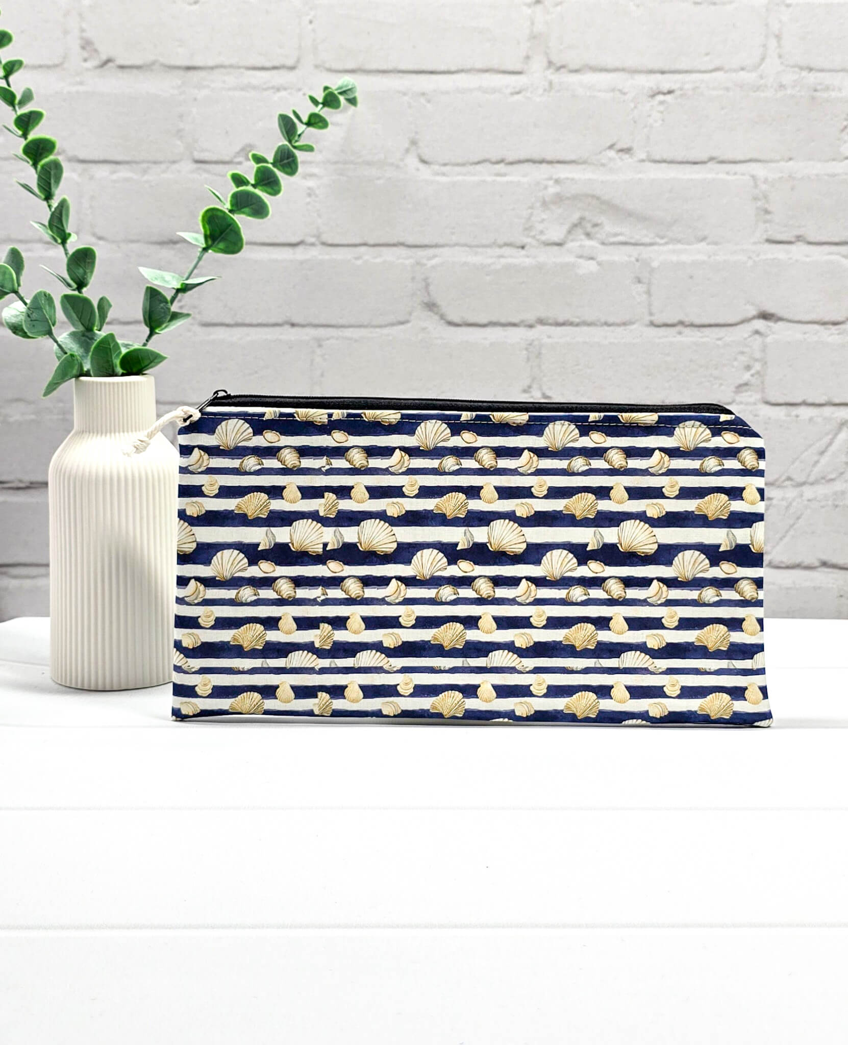Flache, rechteckige Zip Pouch Runa mit dunkelblau-weißen Querstreifen und kleinen Muschelmotive, handgenäht in Bayern von Nadelmikado