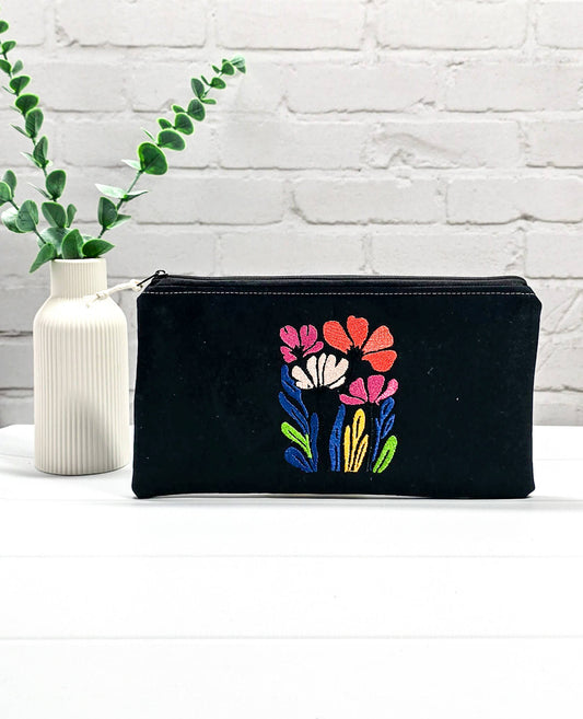 Flache, rechteckige Zip Pouch Runa aus schwarzem Stoff mit einer großen, bunt gestickten Wildblumengruppe, ideal zum geschützten Aufbewahren von Nadelspielen und Scheren. Handgenäht in Bayern von Nadelmikado.