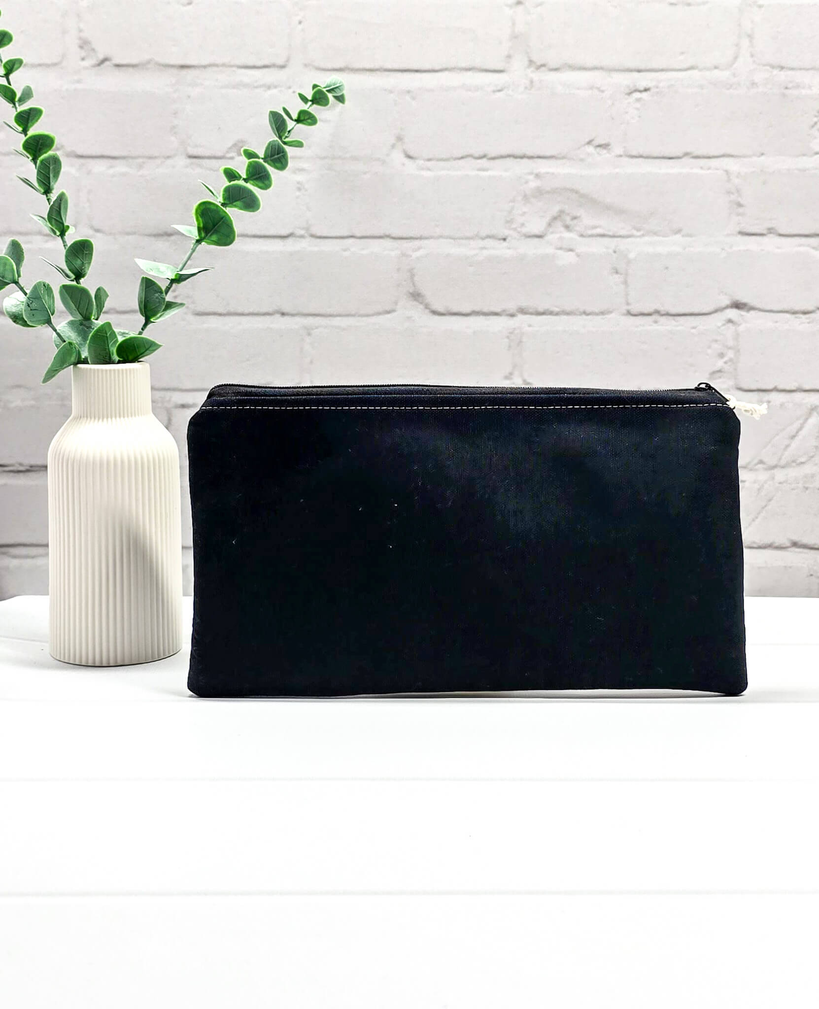Flache, rechteckige Zip Pouch Runa aus schwarzem Stoff mit einer großen, bunt gestickten Wildblumengruppe, ideal zum geschützten Aufbewahren von Nadelspielen und Scheren. Handgenäht in Bayern von Nadelmikado.